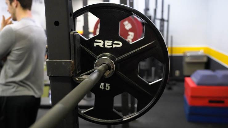 Rep Fitness Equalizer Iron Plates on a barbell on a squat rack