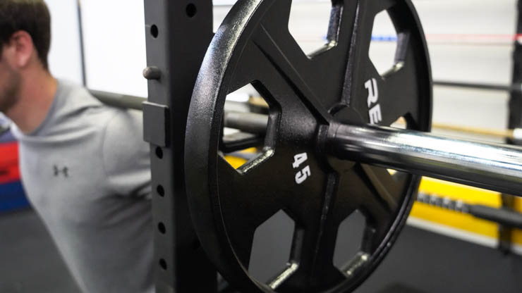 man using the Rep Fitness Equalizer Iron Plates on a barbell