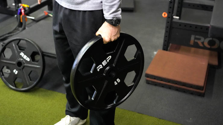 coop holding the 45 pound Rep Fitness Equalizer Iron Plate