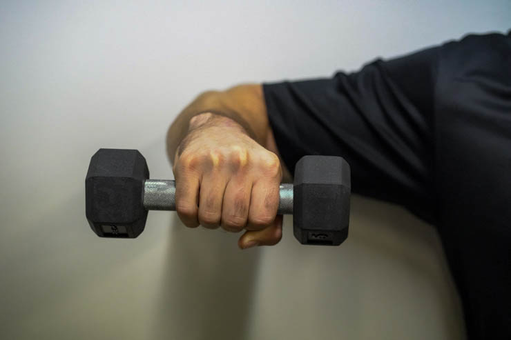 A hand holding a smaller REP rubber hex dumbbell.