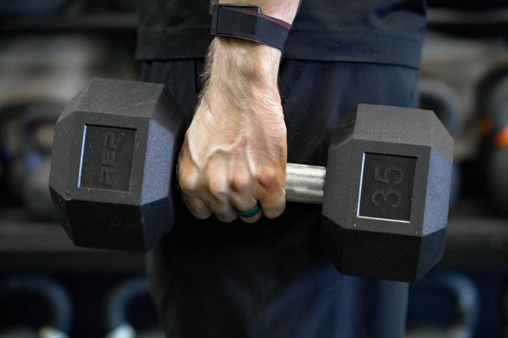 Someone holding the 35-pound REP Fitness dumbbell. 