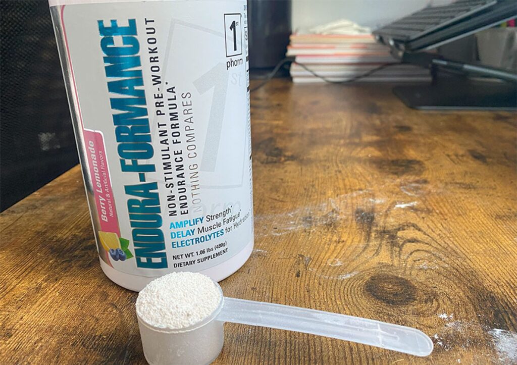 A scoop of powder is shown next to a container of 1st Phorm Endura-Formance