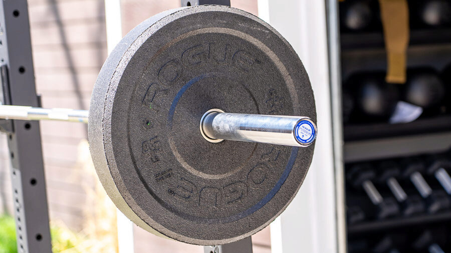A Rogue US MIL Spec Bumper Plate on a barbell outdoors