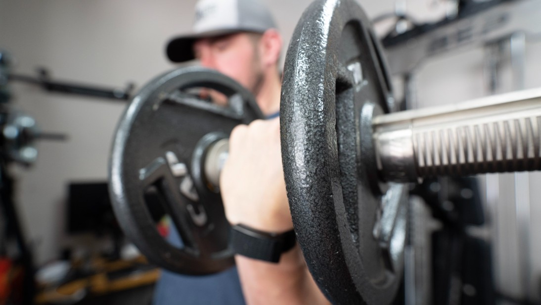 A man performing dumbbell curls using the CAP Barbell Olympic Grip Plates