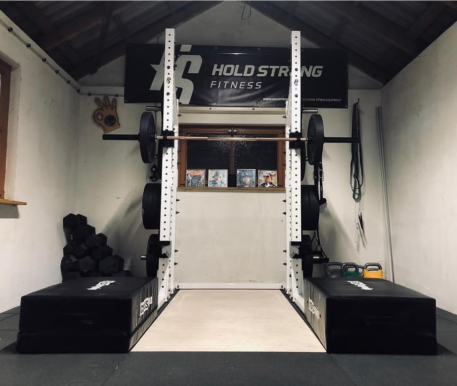 image of a bare bones garage gym with a squat rack and blocks