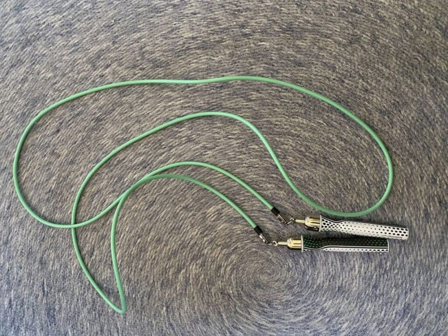 Overhead view of the green CrossRope Get Lean Jump Rope with gold bearings and white and black dot-patterned handles