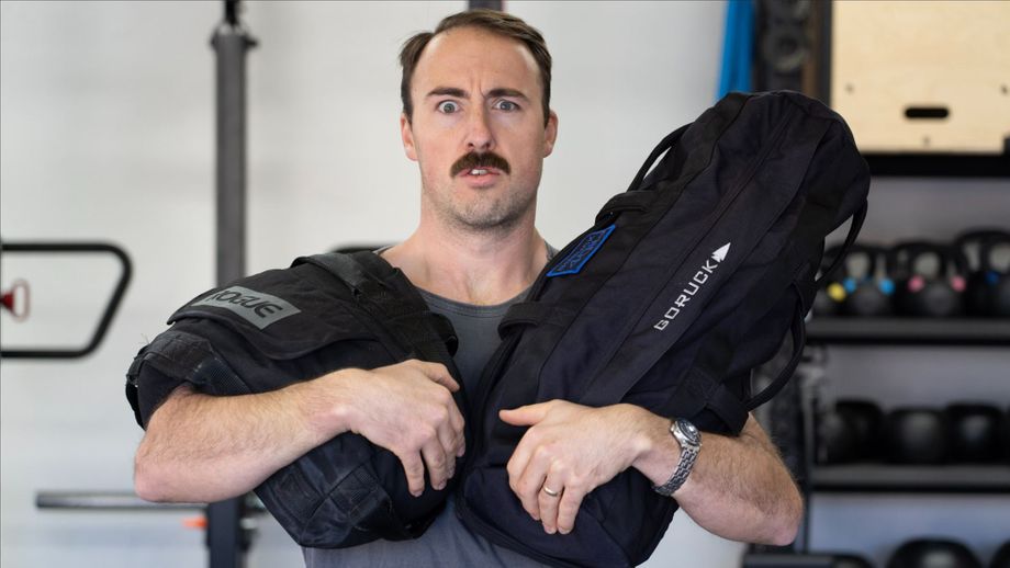 Coop holding two sandbags in comparison for the best workout sandbag guide