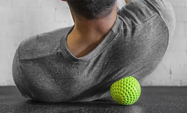 An image of a man using Rogue's dimple ball on his upper back