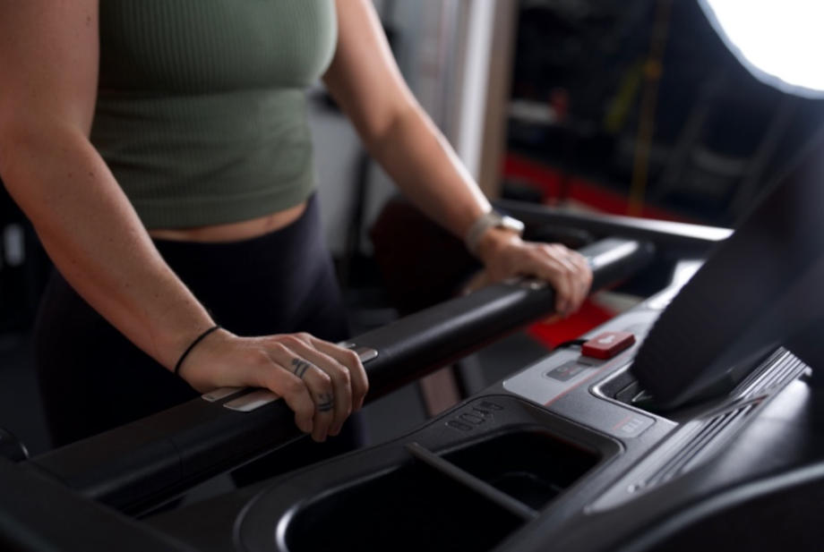 woman holding onto sole fitness tt8 treadmill handles