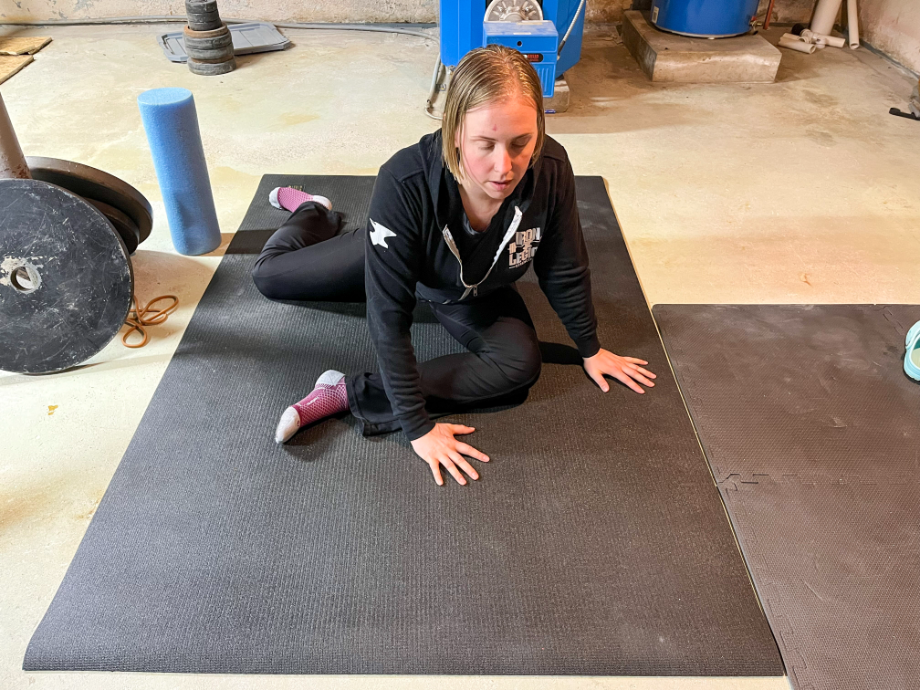 woman performing 90-90 stretch on gxmmat oversized mat