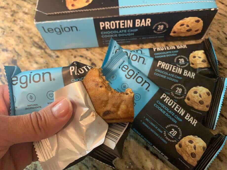 Person holding a half-eaten Legion Protein Bar