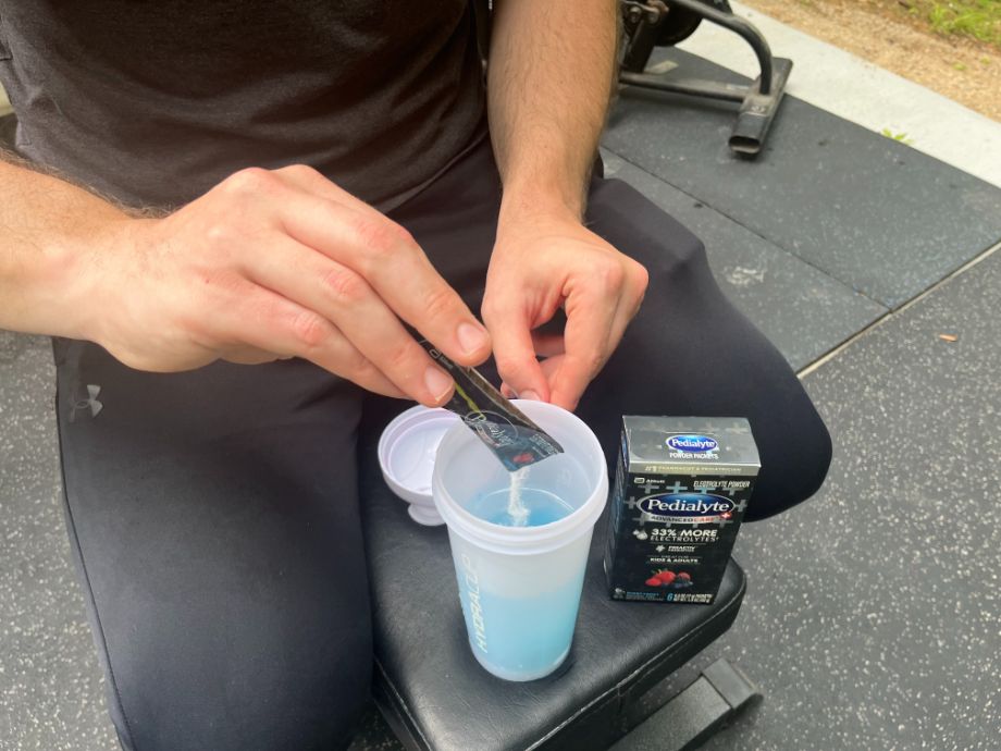 Man mixing Pedialyte Electrolyte into a shaker cup