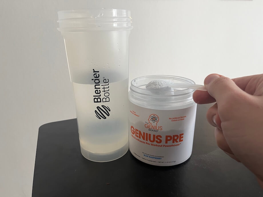 Person scooping Genius pre-workout, a stim-free formula