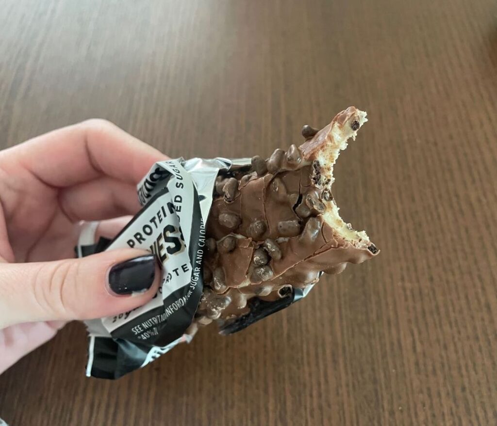 An image of a hand holding a Barebells protein bar