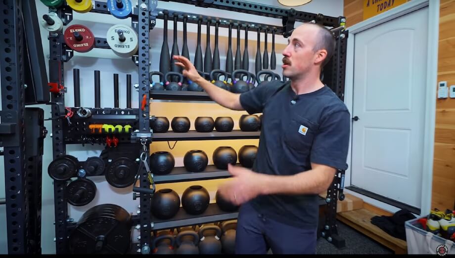 A man showing off his home gym storage shelves