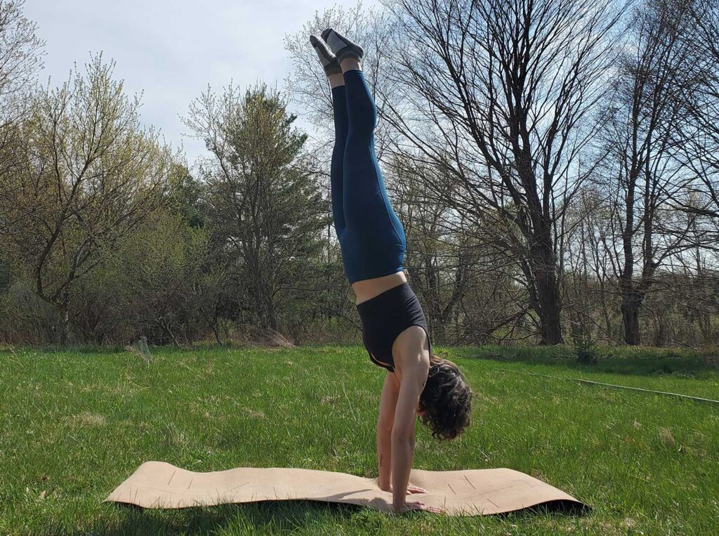 A woman does a handstand in Sweaty Betty High-Waisted Leggings