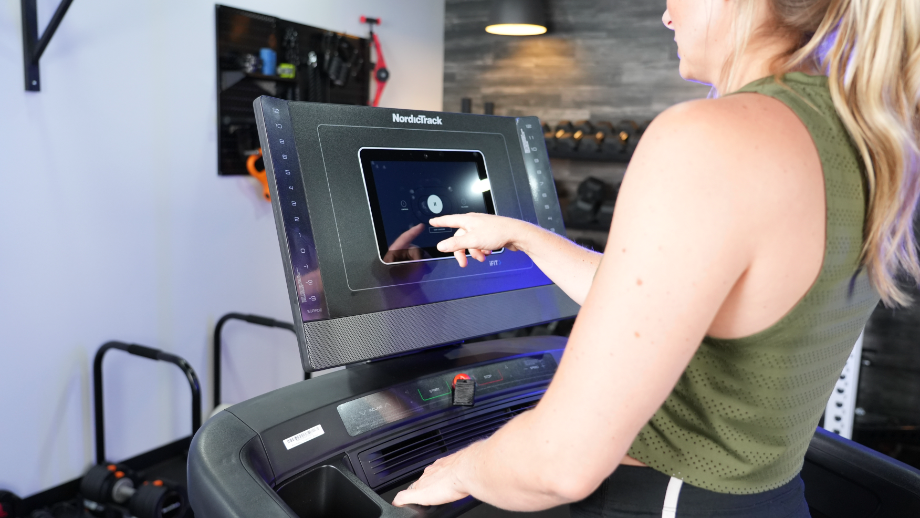 Woman using the display screen of the NordicTrack 1250 Treadmill