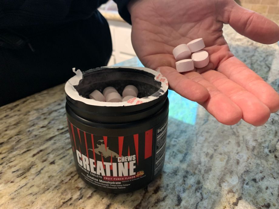 A hand holds out four Animal Creatine Chews