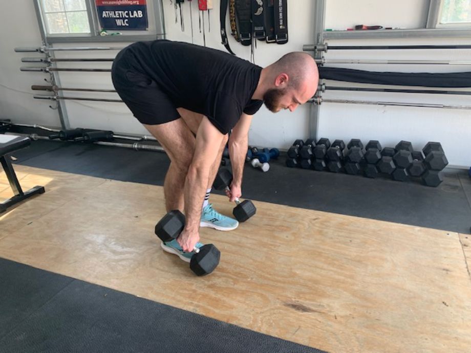 man performing dumbbell deadlifts
