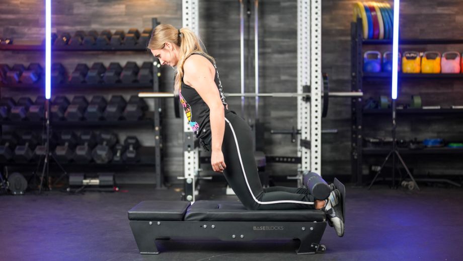 Woman using the BaseBlocks Nordic Plus for Nordic hamstring curls