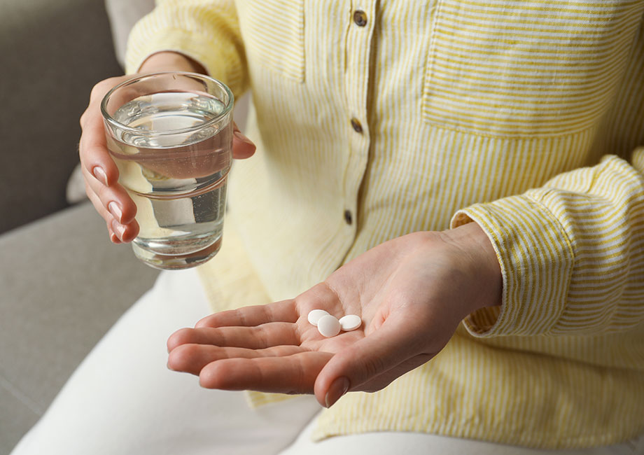 woman-taking-calcium-supplement-with-water