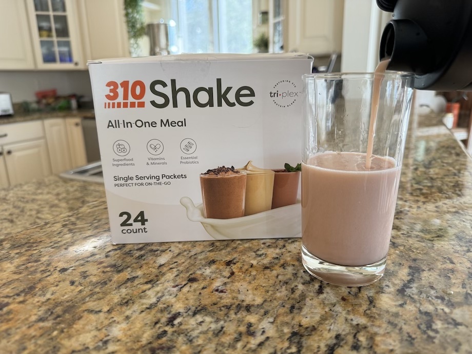 A box of 310 Meal Replacement Shake with a glass of the mixed shake