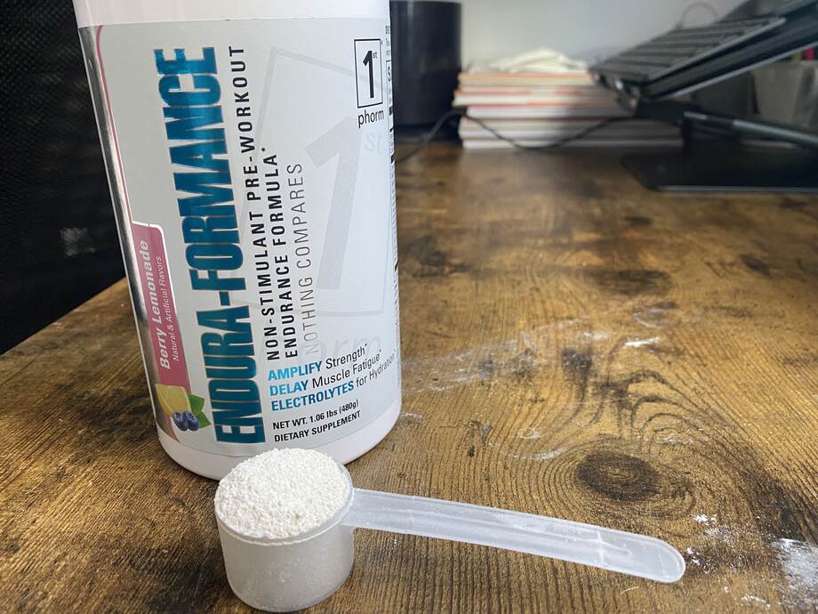 A scoop of 1st phorm endura-formance pre-workout in front of the container