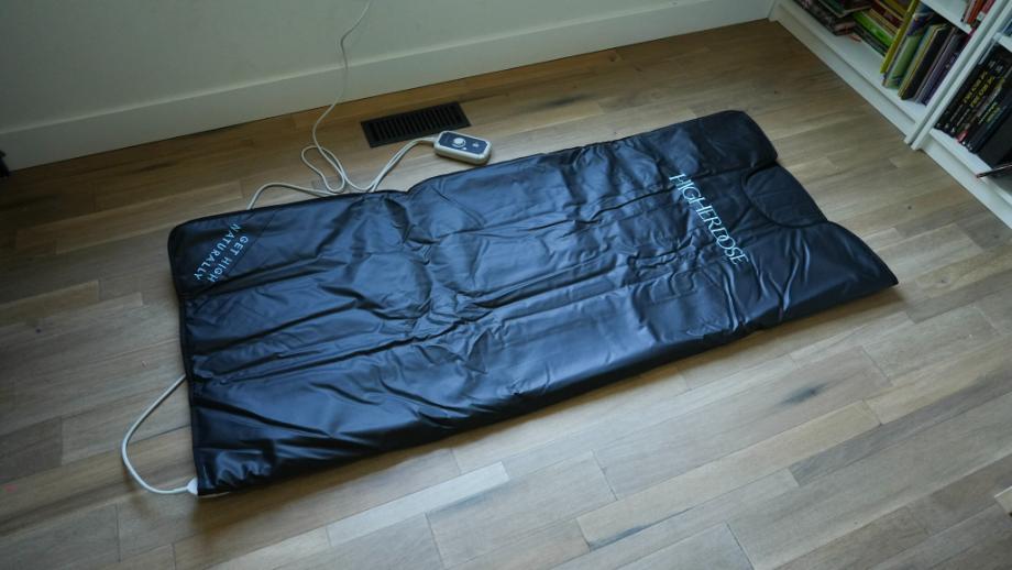 The HigherDOSE Infrared Sauna Blanket rolled out on a floor