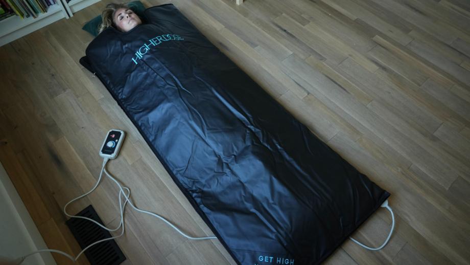 A woman lying in the HigherDOSE Infrared Sauna Blanket