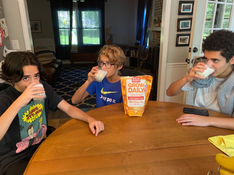 3 kids sit at a table drinking Grow Daily shakes