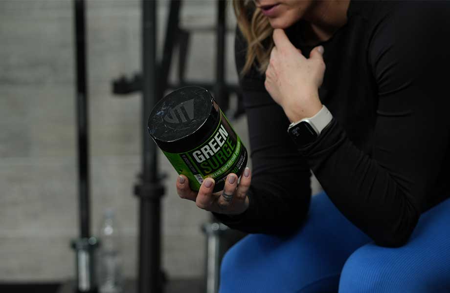 A person carefully contemplating a container of Jacked Factory Green Surge.
