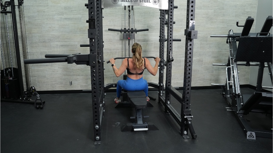 Woman performing lat pulldowns on the Bells of Steel Power Rack