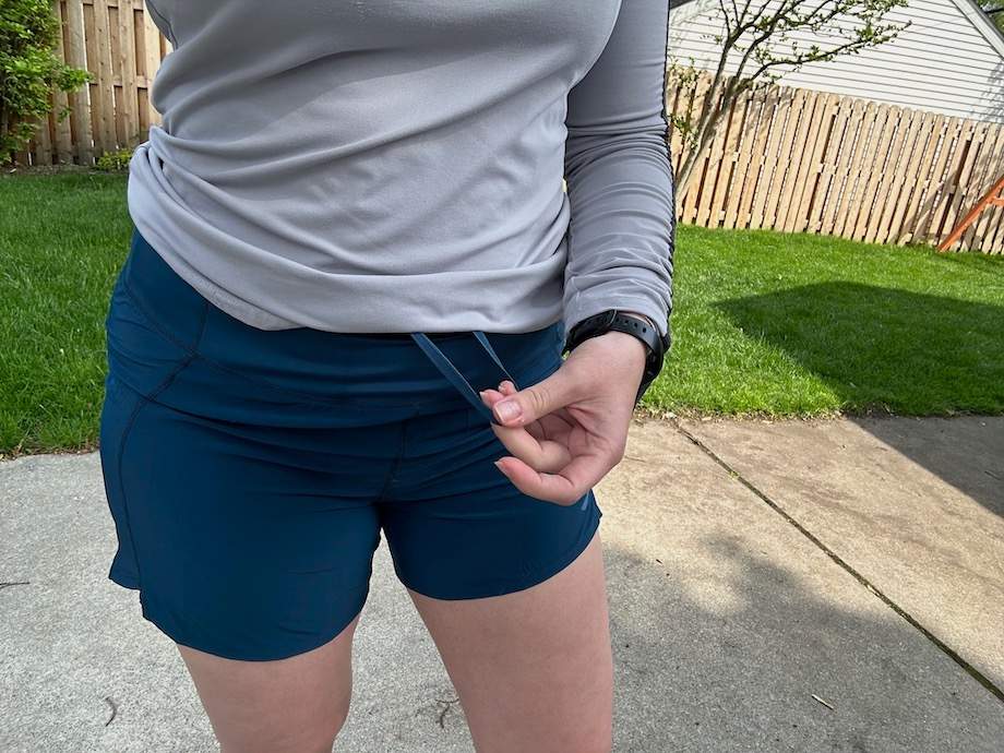 Woman adjusting the infinity drawstring on the Brooks Chaser Short 5"