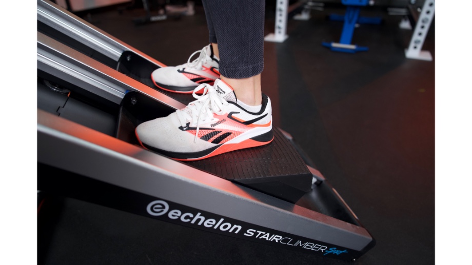 Feet on the steps of an Echelon Stair Climber Sport.