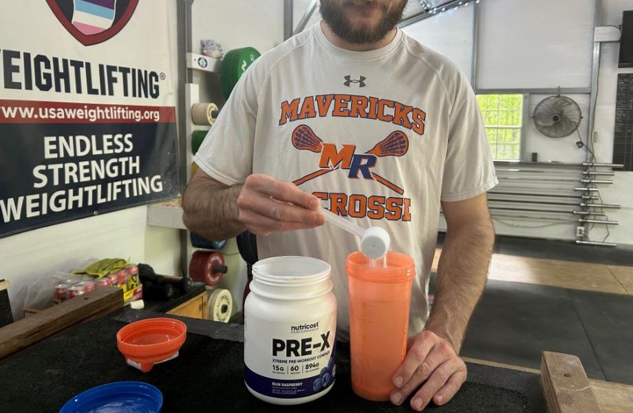 Man pouring out a scoop of Nutricost Pre-X Pre-Workout.