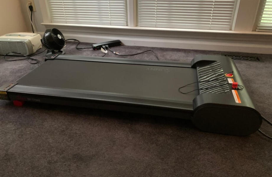 Full view of the Sunny Health & Fitness Under-Desk Treadmill in someone's home.