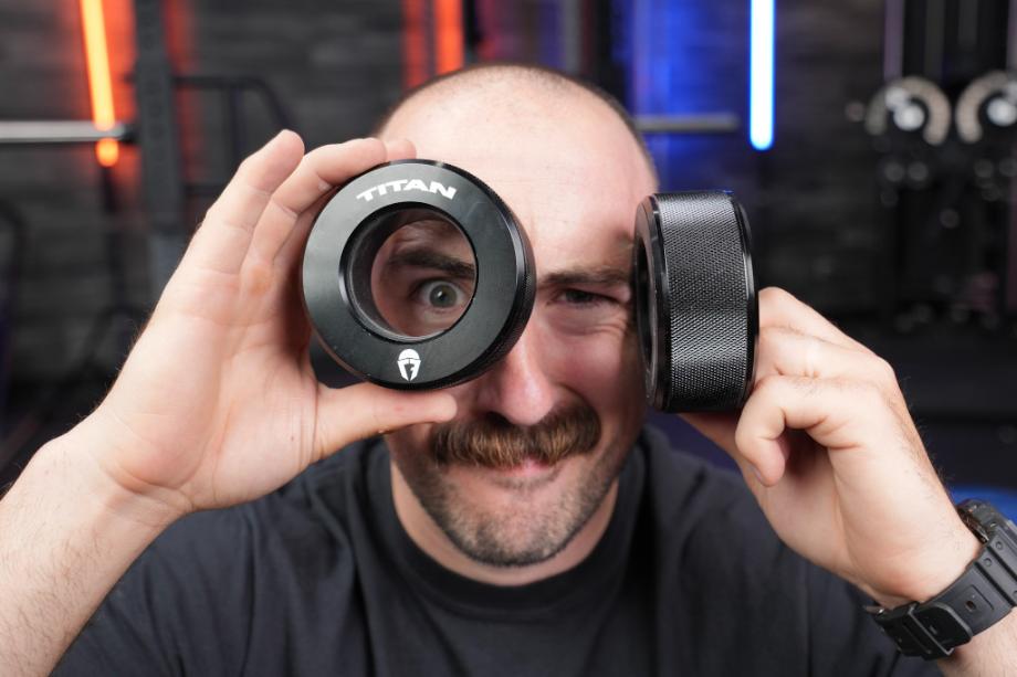 Coop looks through a Titan TwistLock Pro Barbell Collar like a spyglass.