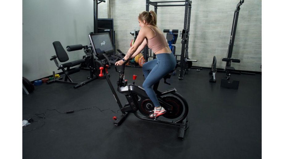 Woman riding Bowflex VeloCore bike