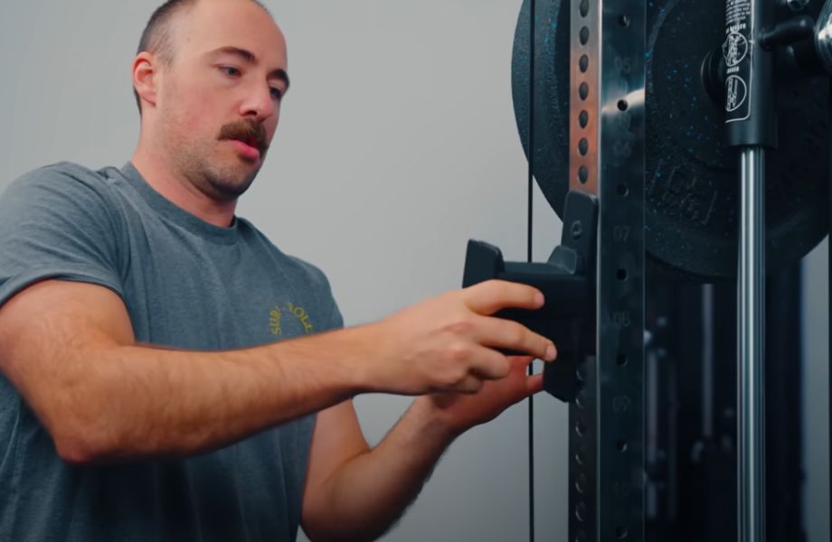 Man moving J-hooks on Force USA G15