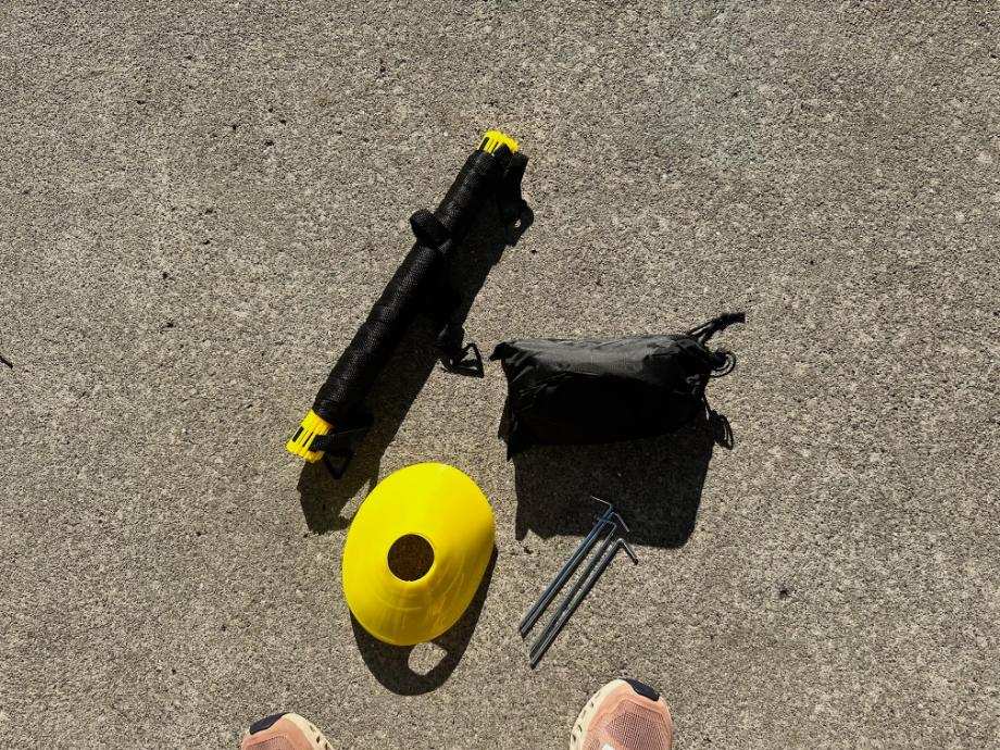 Accessories for the Juvale Agility Ladder are spread out on the ground for the world to see.