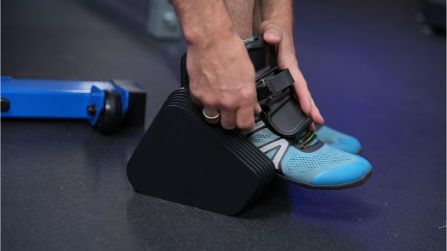 MonkeyFeet Pro on a mans foot with his hands adjusting the strap..