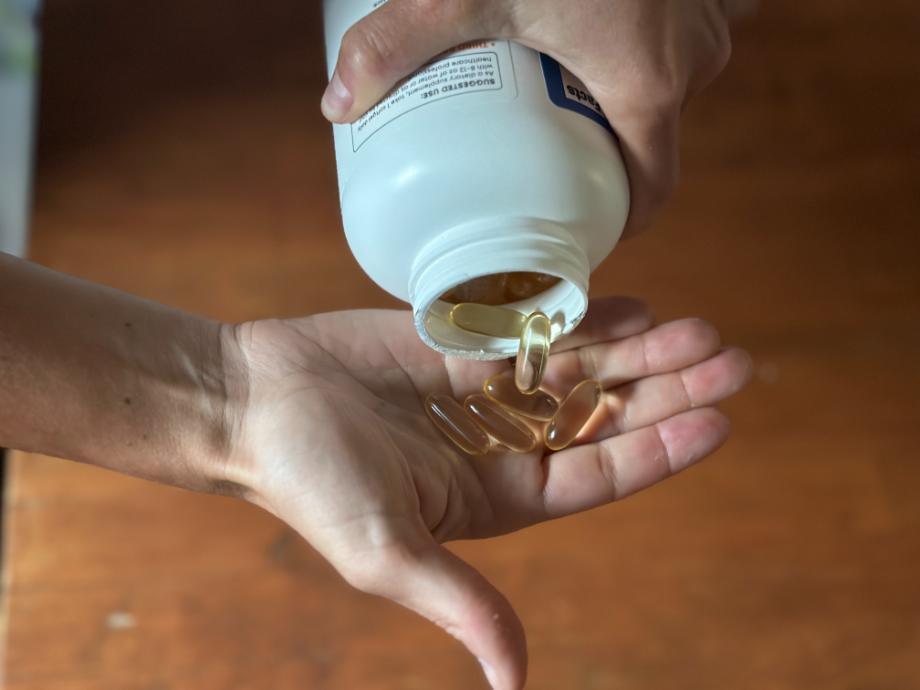 Woman pouring Nutricost Fish Oil into hand