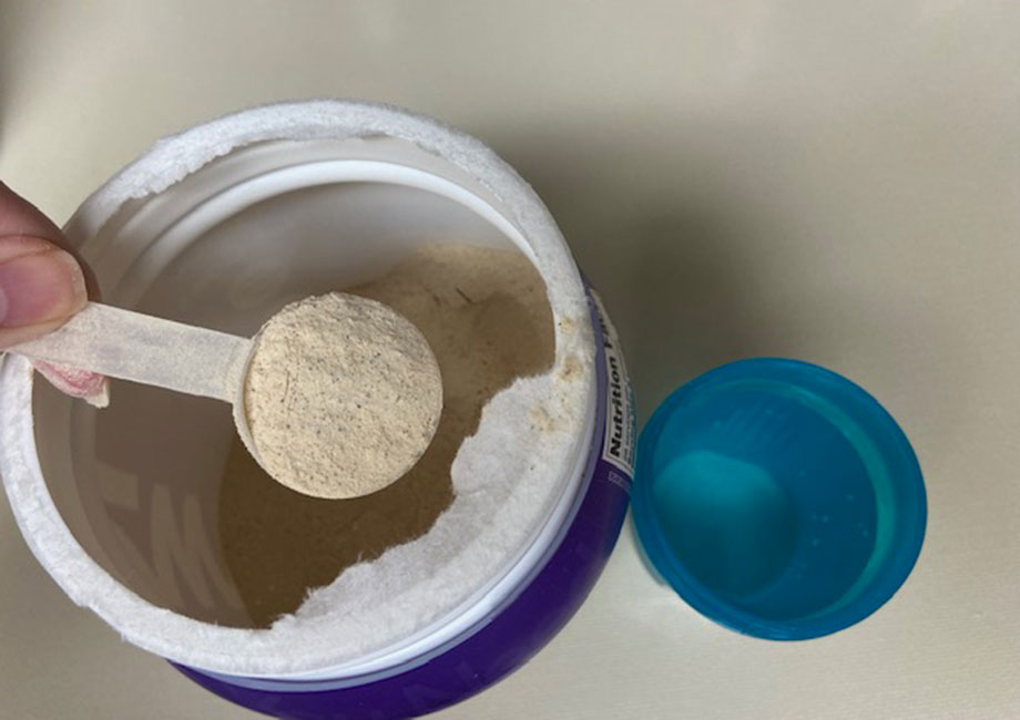 Scooping up some OWYN Protein Powder.