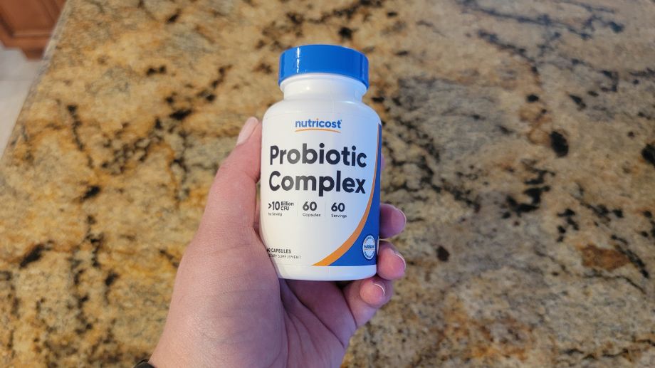 Person holding a bottle of Nutricost Probiotic Complex