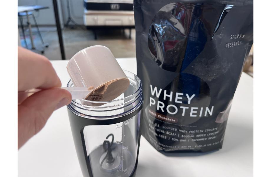 Scooping Sports Research Whey Protein into Blender bottle