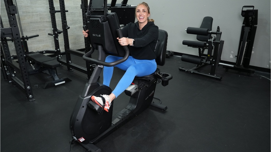 A person smiling while riding the Sole LCR Recumbent Bike