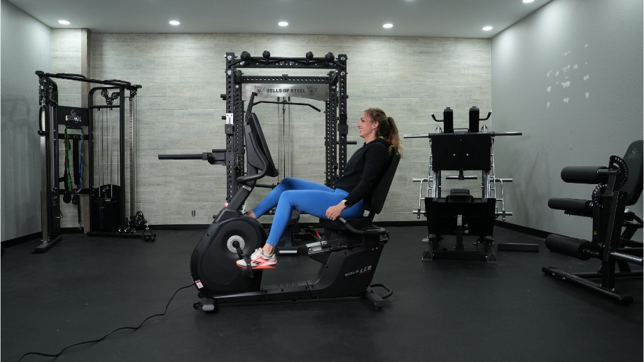 Full side view of a person riding the Sole LCR Recumbent Bike.