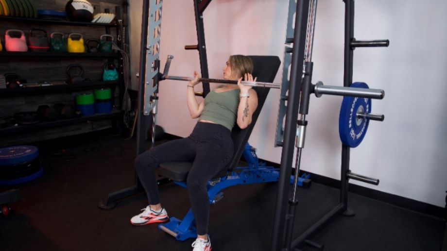 Full view of someone doing a bench press in the Titan Smith Machine.