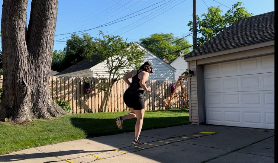 A woman appears to be playing hopscotch with the Juvale Agility Ladder.