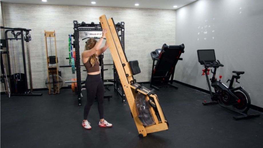 A Person lifts a WaterRower for vertical storage.